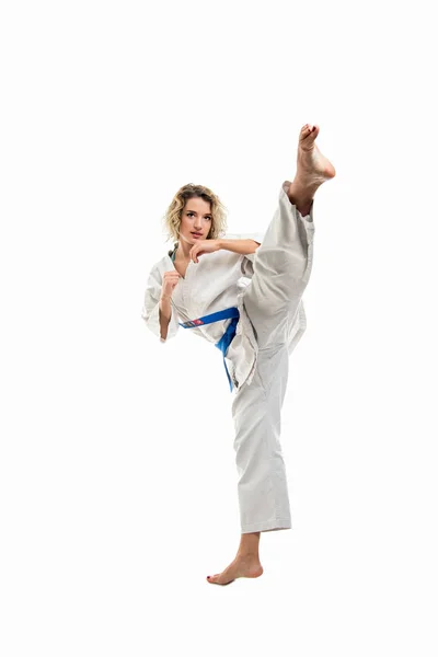 Female wearing martial arts uniform making karate move isolated on white background