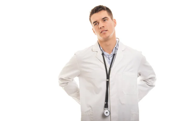 Portrait of young handsome doctor holding lower back like hurtin — Stock Photo, Image