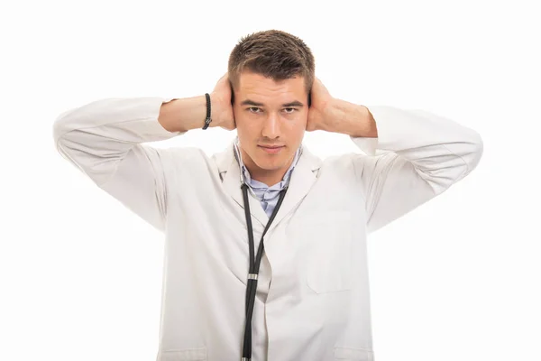 Portrét mladý pohledný doktor pokrývající uši jako neslyšící precizní — Stock fotografie