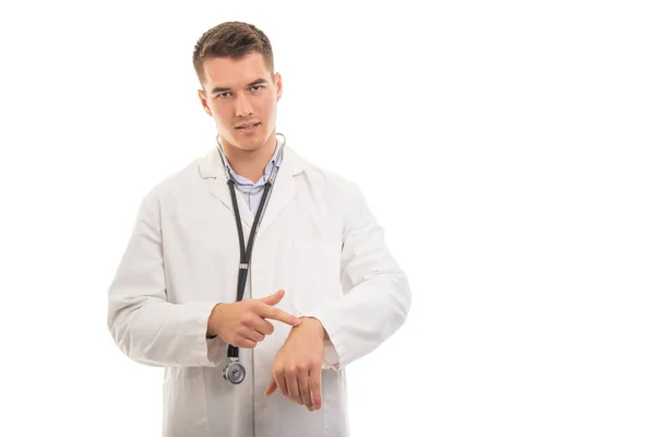 Retrato de un joven médico guapo mostrando reloj como llegar tarde —  Fotos de Stock