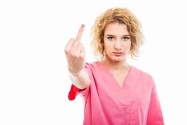 Orta parmağını gösteren pembe önlük giyen genç hemşire portresi