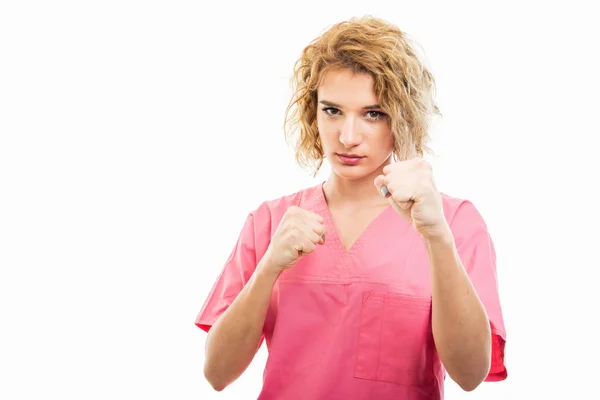 Ritratto di infermiera con scrub rosa che mostra i pugni — Foto Stock