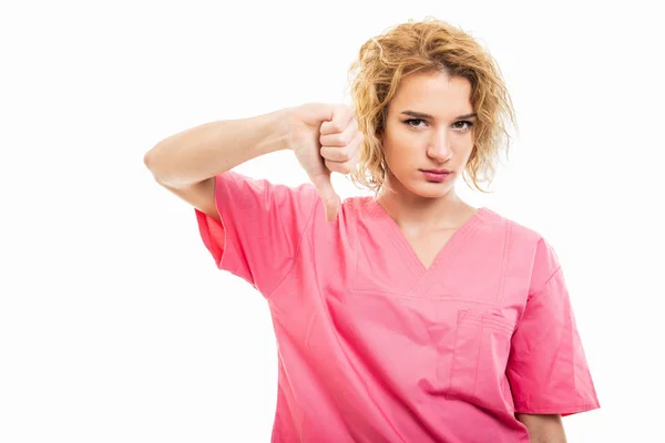 Portrait of young nurse wearing pink scrub showing dislike gestu — Stock Photo, Image