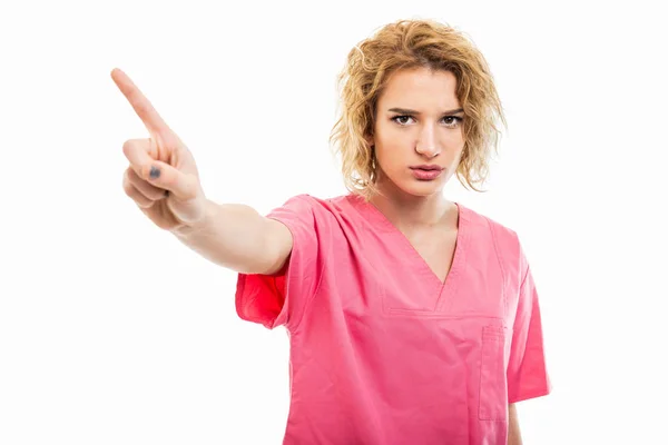 Портрет медсестры в розовом скрабе с отрицательным жестом — стоковое фото