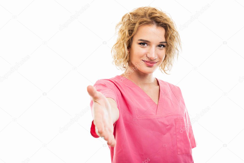 Portrait of young nurse wearing pink scrub offering hand shake