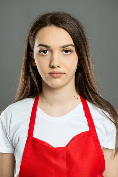 Portret Młodej Atrakcyjnej Pracowniczki Supermarketu Czerwonym Fartuchu Szarym Tle — Zdjęcie stockowe