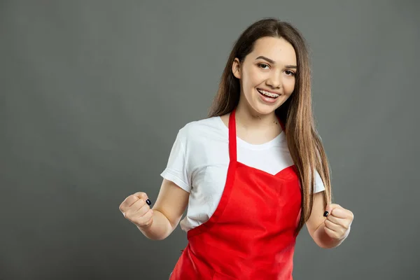 Porträt Einer Jungen Supermarkt Mitarbeiterin Mit Siegergeste Auf Grauem Hintergrund — Stockfoto