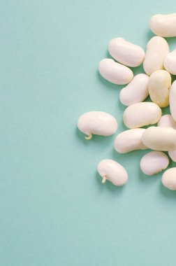 Organik taze beyaz barbunya fasulyesi mavi zemin üzerine. makro 