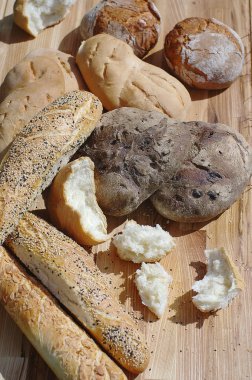 Assortiment taze ekmek, baget, yeşil çim bir arka plan üzerinde bir ahşap stand buns