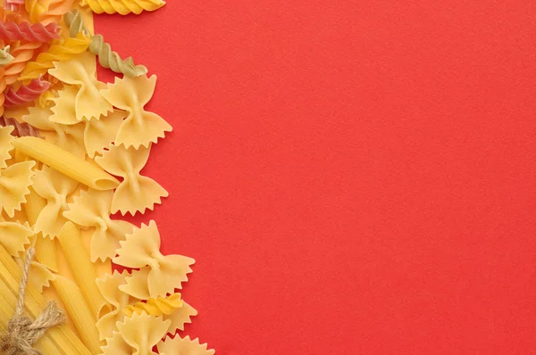 Various Types Uncooked Pasta Orange Background Top View Place Text — Stock Photo, Image