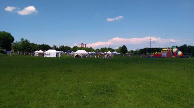 Parkta güneşli bir günde eğlence de oynayan ebeveynler ve çocuklar