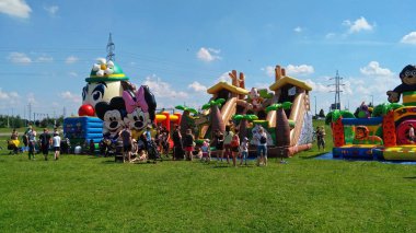 Parkta güneşli bir günde eğlence de oynayan ebeveynler ve çocuklar