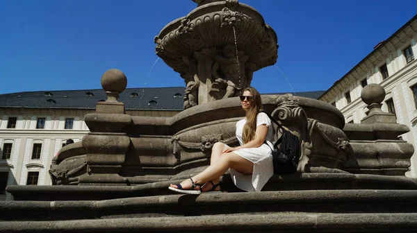 Prag 'daki Prag Kalesi' nde güneşli bir günde fıskiyenin yanında poz veren genç kız öğrenci. — Stok fotoğraf