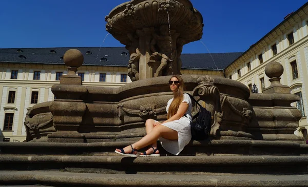 Prag 'daki Prag Kalesi' nde güneşli bir günde fıskiyenin yanında poz veren genç kız öğrenci. — Stok fotoğraf