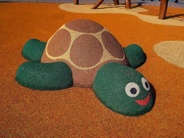 The figure of a turtle on the playground made of soft rubber crumbs in Prague