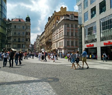 İnsanlar güneşli bir günde Prag'ın merkezinde yürürler.