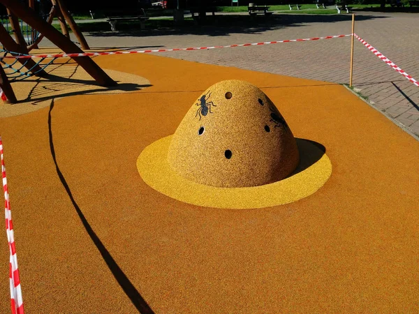 The figure of an anthill on the playground of soft rubber crumb in Prague