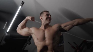 Pompalı adam spor salonunda antrenman yapıyor. Vücut geliştirici dambıl, egzersiz makinesi, halter pompalıyor.