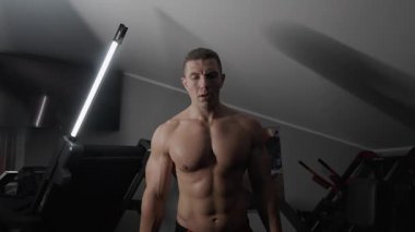 Pompalı adam spor salonunda antrenman yapıyor. Vücut geliştirici dambıl, egzersiz makinesi, halter pompalıyor.