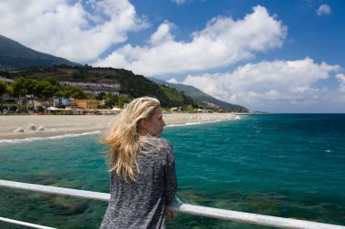 Sarışın kadın açık, gök mavi deniz arka plan, plaj ve dağ Sicilia, İtalya