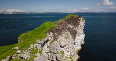 Kayalık deniz kıyısında, insanlar Kinbane kalede Antrim sahil, Kuzey İrlanda, küçük bir yarımada kenarına hiking
