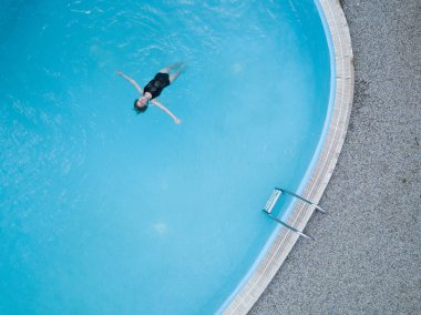 Kuşlar göz görünümünü açık havuzu ve uzun saç siyah mayo kız suda yüzüyor