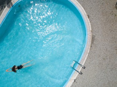 Kuşlar göz görünümünü açık havuzu ve uzun saç siyah mayo kız suda yüzüyor