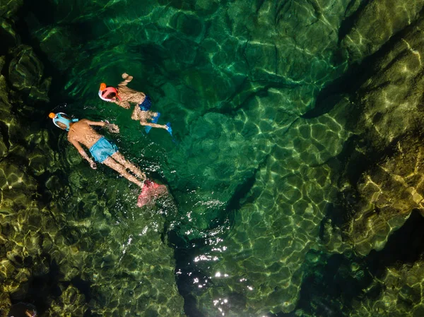 透き通った緑色の水でシュノーケ リングの男の子泳ぐダイビング マスク ギリシャ 空中ドローン写真 — ストック写真