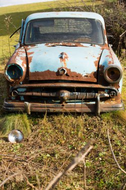 Eski, paslı araba enkazı açık açık.