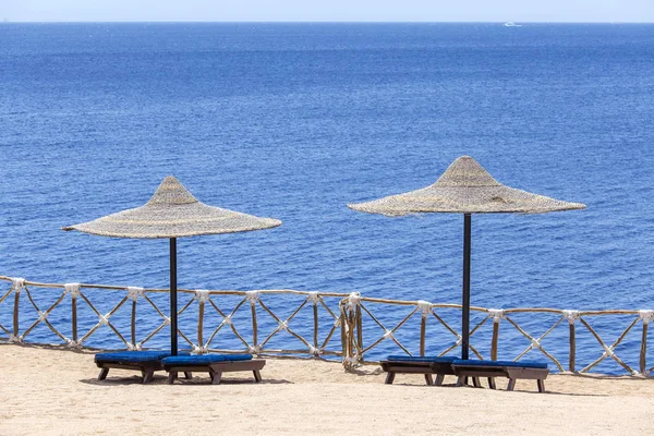 Due Ombrelloni Paglia Spiaggia Con Sedie Sdraio Legno Vicino Mare — Foto Stock