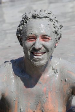 Türkiye, Dalyan 'da çamur tedavisi. Çamur banyosu yapan mutlu adamın portresi.