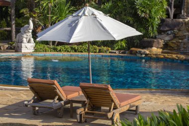 Yüzme Havuzu, palmiye ağaçları, daybeds ve deniz, Tayland yakınındaki bir tropik bahçe şemsiye ile güzel bir plaj