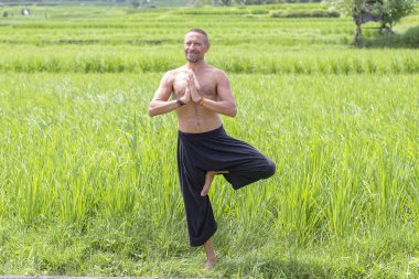 Yeşil pirinç Teras tropikal Adası Bali, Endonezya yakın bir konumda meditasyon ve Yoga yapıyor adam. Yakın çekim