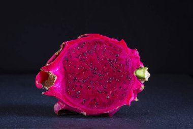 Egzotik pembe dragonfruit siyah arka plan üzerine kesilmiş. Dragon meyve kapatın. Olgun kırmızı pitahaya meyve yarısı. Tatlı tropikal meyve, sulu pitaya kesim