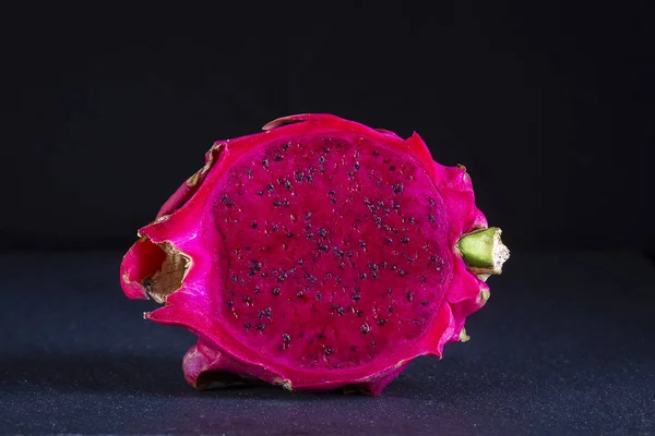 エキゾチックなピンク Dragonfruit は黒い背景にカット ドラゴン フルーツをクローズ アップ 熟した赤いピタハヤ フルーツ半分 甘いトロピカル フルーツ — ストック写真