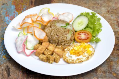 Fried rice ile sebze, pirinç cips, peynir tofu ve masada, kızarmış yumurta yakın çekim. Ada Bali, Endonezya'da Servis Kahvaltı
