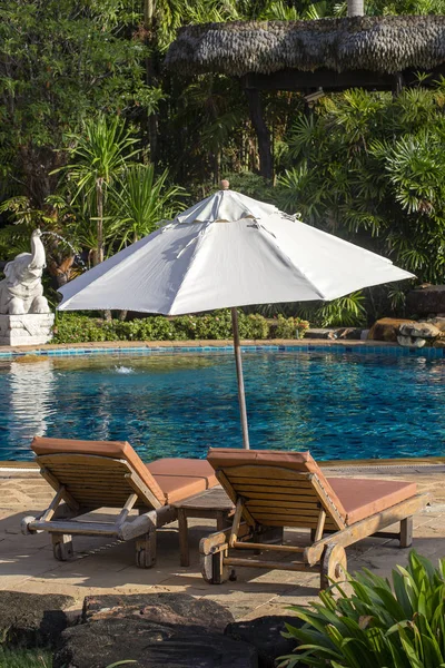 スイミング プール ヤシの木 寝台兼用の長椅子 タイの近くのトロピカル ガーデンで傘を持つ美しいビーチ — ストック写真