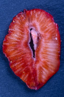 Siyah arkaplanda kırmızı çilek dilimi, yakın plan, üst görünüm