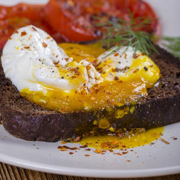 煎蛋在一块面包与油炸的红色蕃茄 — 图库照片