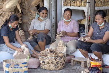 Ubud, Bali, Endonezya - 23 Mart 2015: Kimliği belirsiz kadın ahşap Hatıra Eşyası turistler için yapıyoruz. Bali, Endonezya geleneksel el sanatları oymacılığı olduğunu