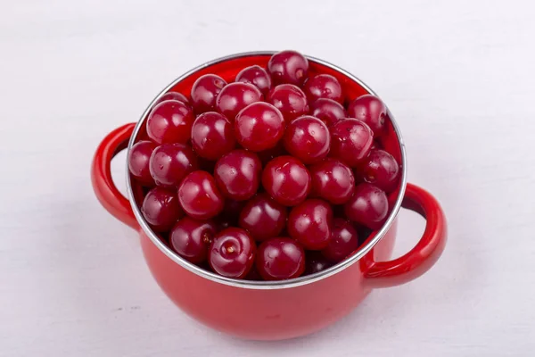 Red Cherries Red Enamel Saucepan White Background Close — Stock Photo, Image