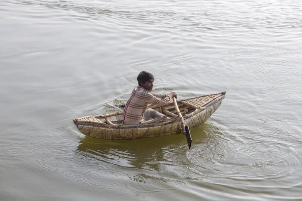 Varanasi, Hindistan - 28 Ocak 2017: Bilinmeyen Hintli adam Varanasi Ganj Nehri, sabahleyin yola çıktı küçük bir ahşap tekne vardır. Uttar Pradesh, Hindistan