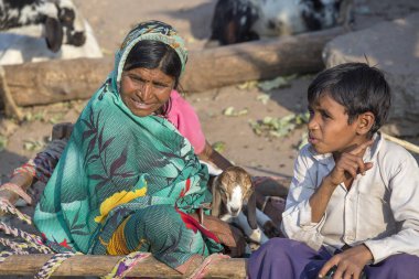 Mandu, Hindistan - 03 Şubat 2017: Tanımlanamayan bir Hint Aile goatling ile sokakta oturuyor. Yoksulluk Hindistan önemli bir konudur