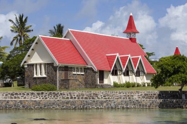 Kırmızı çatılı bir kumsalda bulunan Cap Malheureux Mauritius Adası Kilisesi