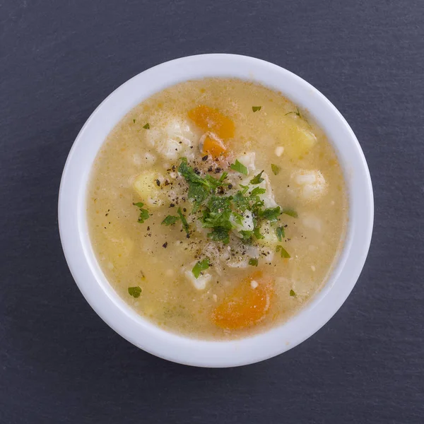 Fresh vegetable soup made of carrot, potato, cauliflower, parsley and rice in white plate, close up — Stock Image Fresh Vegetable Soup Made Carrot Potato Cauliflower Parsley Rice White Stock Image
