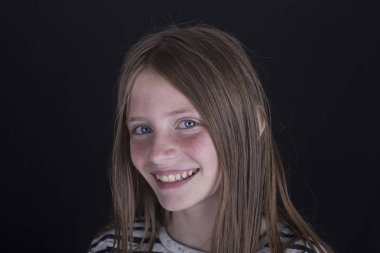 Siyah arka planda çilli güzel sarışın kız, portreyi kapat.