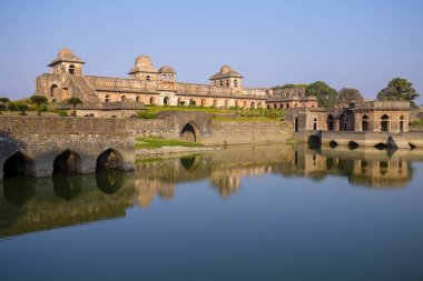 Gündoğumu Jahaz Mahal, gemi Sarayı ve mavi su göl. Mandu, Madhya Pradesh, Hindistan. Arka planda eski Hint mimarisi
