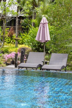 Yüzme Havuzu, palmiye ağaçları, daybeds ve deniz, Tayland yakınındaki bir tropik bahçe şemsiye ile güzel bir plaj