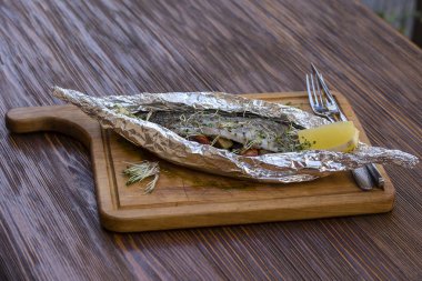 Sebze ve folyoyla pişirilmiş alabalık.