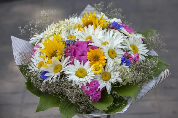 Bouquet of different wild flowers close-up. Bouquet of flowers for sale on the local street market in Lviv, Ukraine